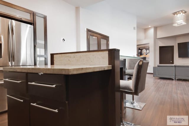 interior space with hardwood / wood-style floors and stainless steel refrigerator with ice dispenser