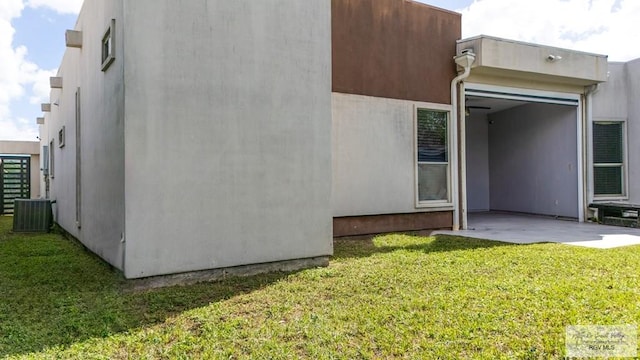 back of house with a lawn, a patio area, and central AC