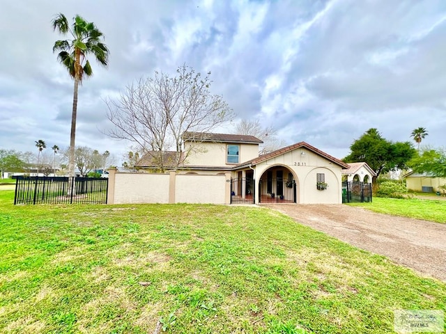 view of front of home with driveway, stucco siding, fence, and a front yard