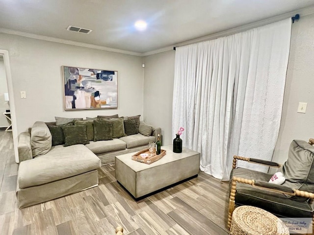 living room featuring crown molding and light hardwood / wood-style floors