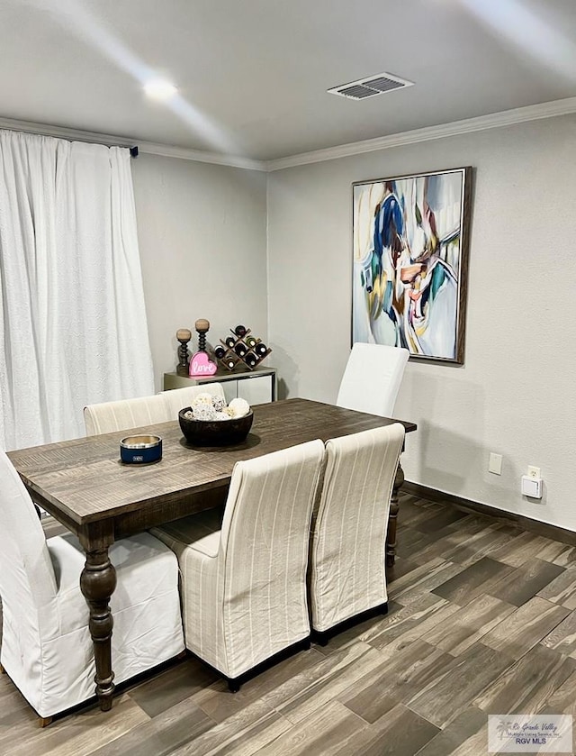 dining room featuring ornamental molding and dark hardwood / wood-style floors