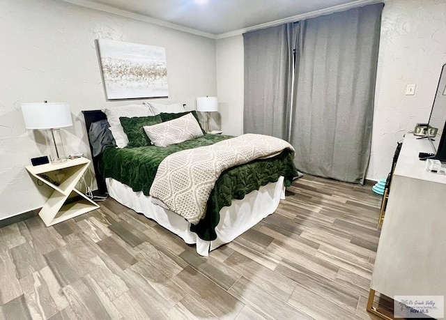 bedroom featuring crown molding and wood finished floors