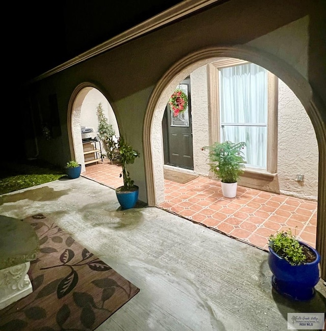 view of exterior entry with a patio area