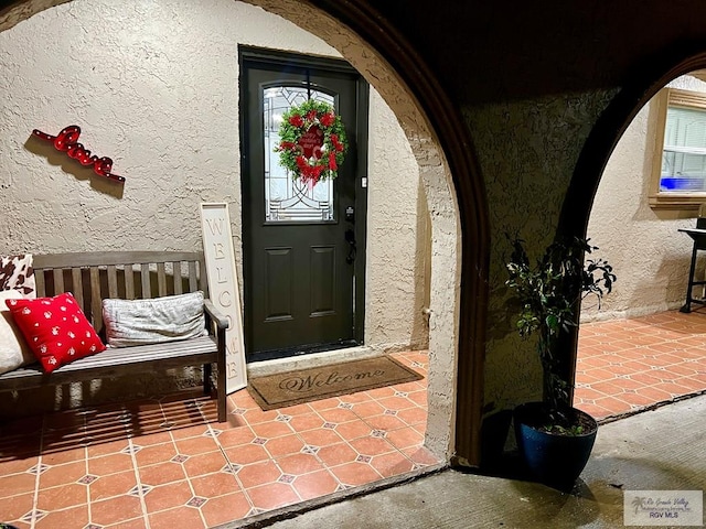 doorway to property featuring stucco siding