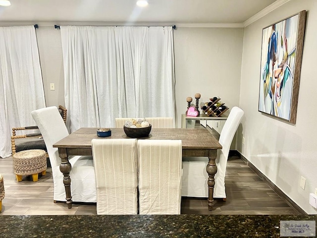 dining room with crown molding, baseboards, and wood finished floors