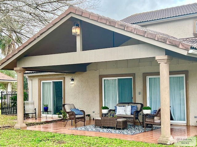 back of house with a tile roof, a patio, stucco siding, outdoor lounge area, and fence