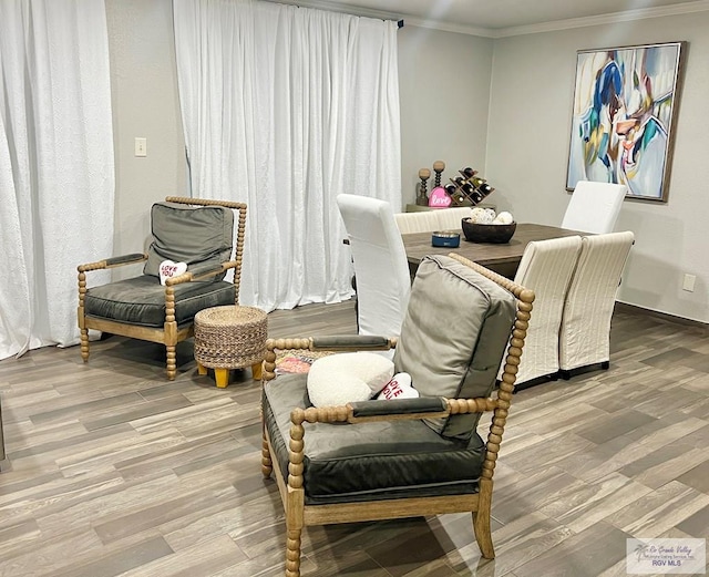 living area with wood finished floors and crown molding