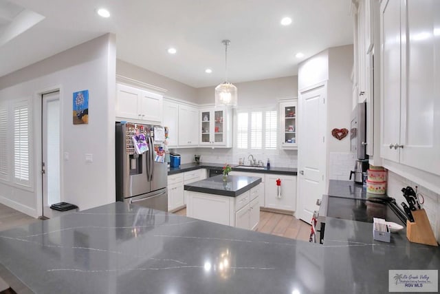 kitchen featuring tasteful backsplash, stainless steel fridge with ice dispenser, white cabinets, and pendant lighting