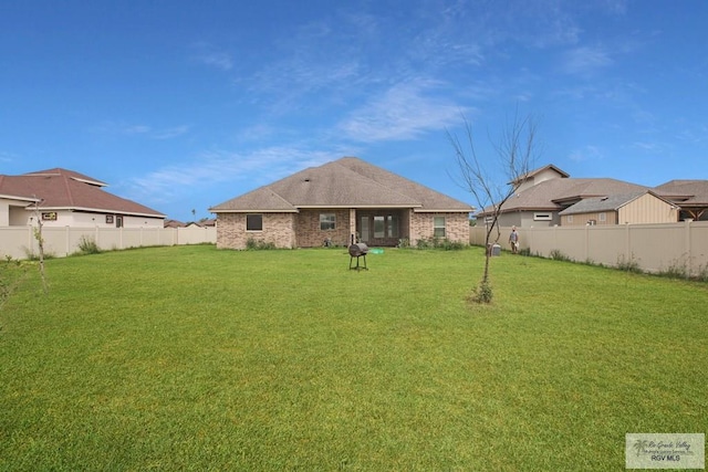 rear view of house featuring a lawn