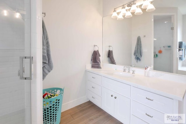 bathroom featuring hardwood / wood-style flooring, vanity, and a shower with shower door