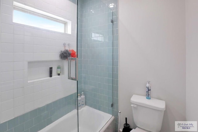 bathroom with shower / bath combination with glass door and toilet