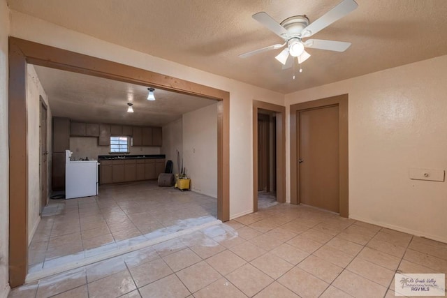 interior space featuring washer / dryer, ceiling fan, a textured ceiling, a sink, and light tile patterned flooring