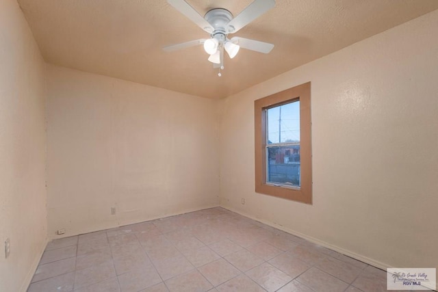 empty room featuring ceiling fan and light tile patterned floors