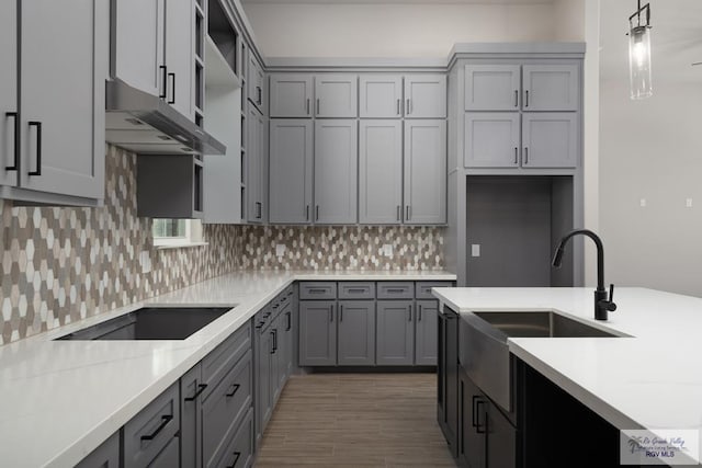 kitchen featuring hanging light fixtures, gray cabinetry, and sink