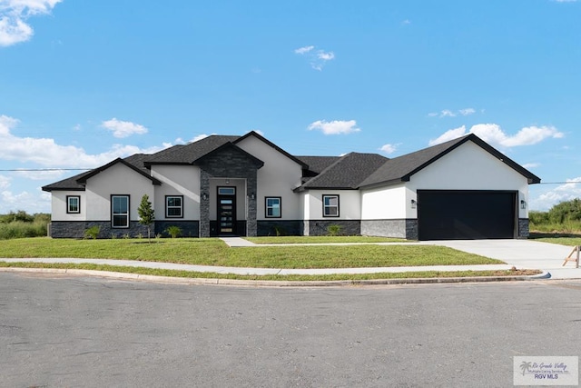 view of front of home with a garage and a front lawn