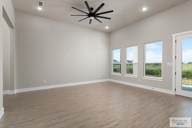 unfurnished room with hardwood / wood-style flooring, a wealth of natural light, and ceiling fan