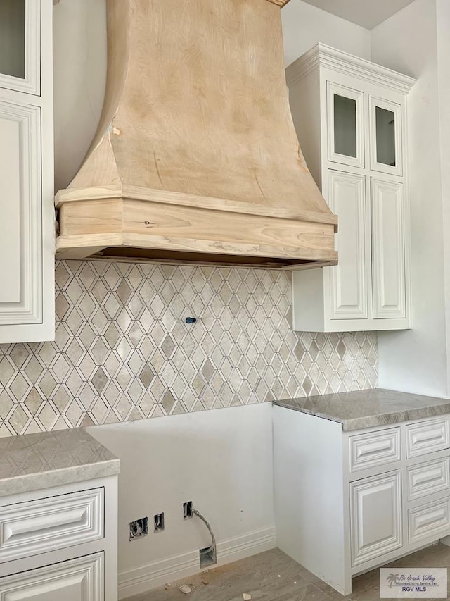 kitchen featuring decorative backsplash, white cabinetry, and hardwood / wood-style floors