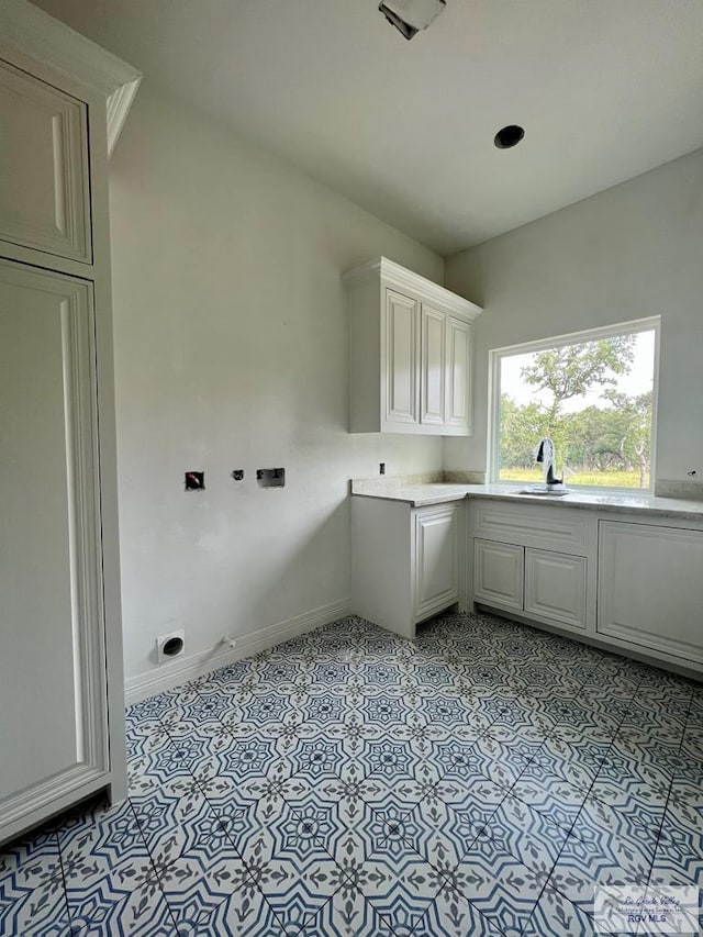 clothes washing area featuring sink and light tile patterned flooring