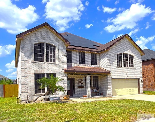 view of front of home featuring solar panels, a garage, and a front yard