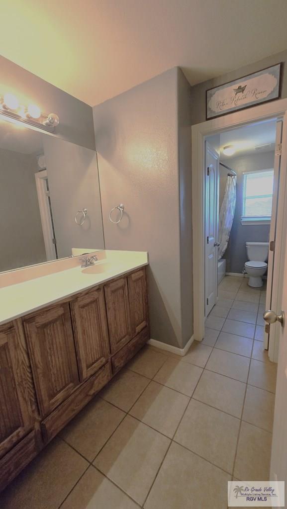 bathroom featuring tile patterned flooring, vanity, and toilet