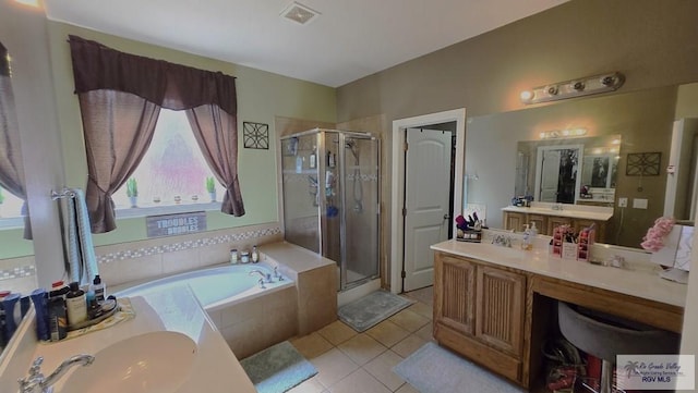 bathroom featuring plus walk in shower, vanity, and tile patterned floors