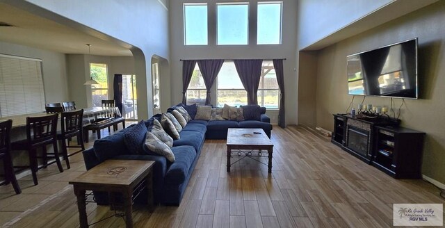 living room with a towering ceiling and hardwood / wood-style flooring