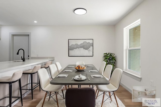 kitchen with white cabinets, light wood-type flooring, and kitchen peninsula