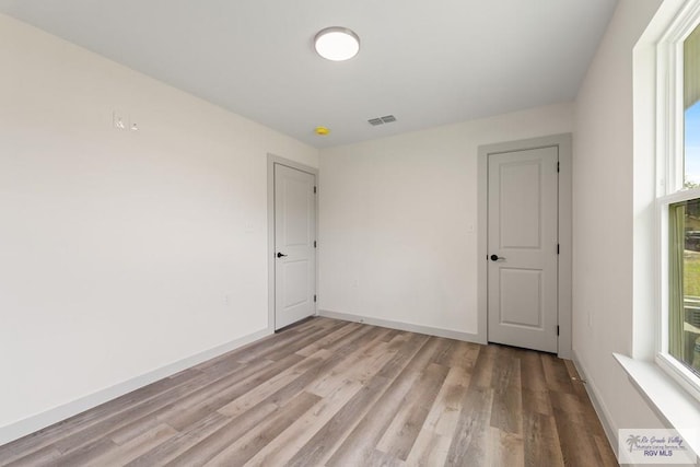 unfurnished room with plenty of natural light and light hardwood / wood-style floors