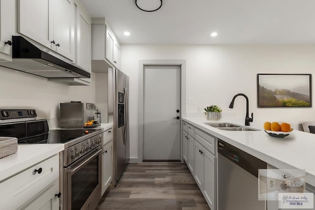 kitchen with appliances with stainless steel finishes, sink, dark wood-type flooring, and white cabinets