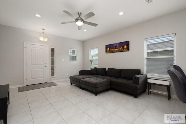 living area with light tile patterned flooring, recessed lighting, visible vents, a ceiling fan, and baseboards