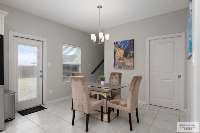 dining room with light tile patterned floors, baseboards, and an inviting chandelier