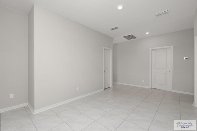 empty room featuring baseboards, visible vents, and recessed lighting