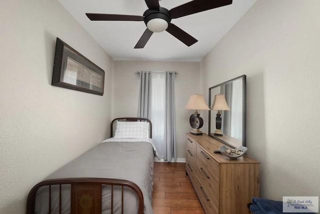 bedroom with dark hardwood / wood-style floors and ceiling fan