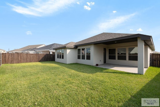 back of house with a yard and a patio