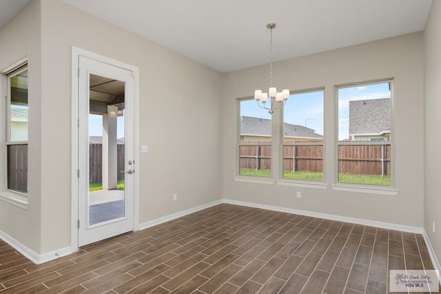 unfurnished dining area featuring a chandelier and dark hardwood / wood-style floors