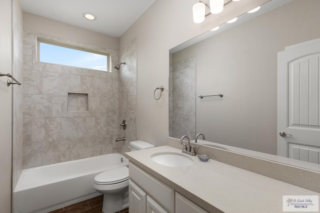 full bathroom featuring tiled shower / bath combo, toilet, and vanity