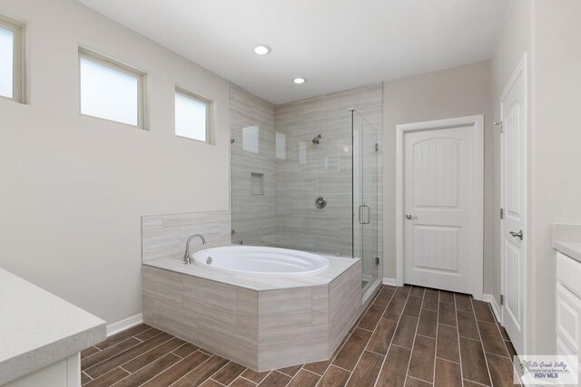 bathroom featuring vanity and independent shower and bath