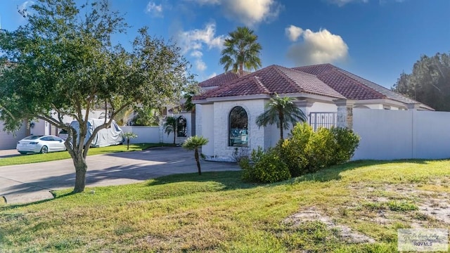 mediterranean / spanish home featuring a front lawn