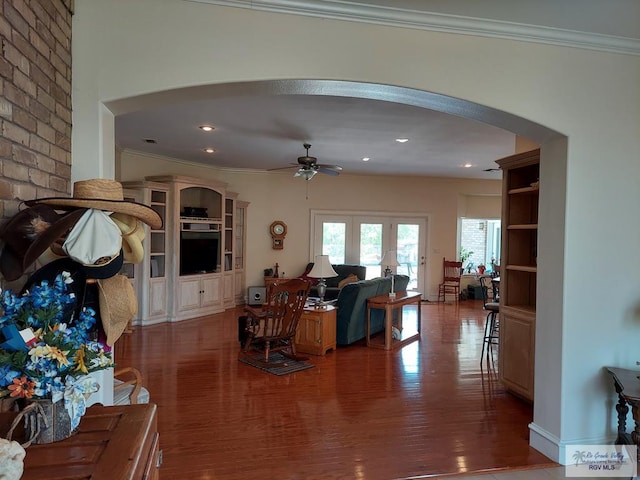 living room featuring hardwood / wood-style floors, ceiling fan, and crown molding