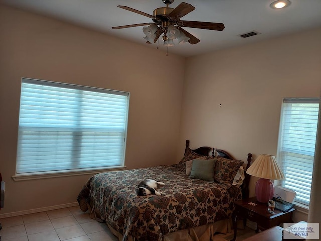 tiled bedroom with ceiling fan and multiple windows