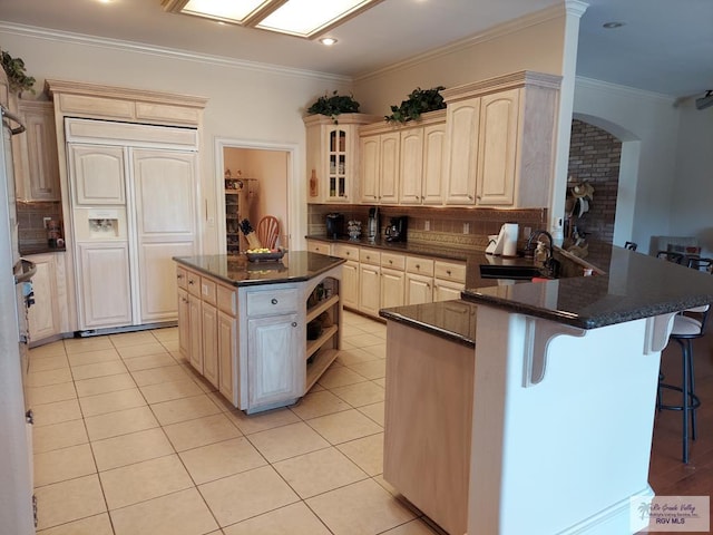 kitchen with decorative backsplash, a center island, paneled refrigerator, and kitchen peninsula