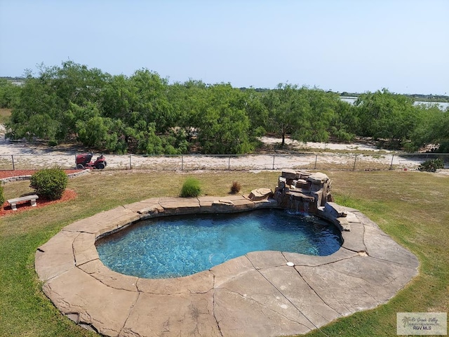 view of swimming pool featuring pool water feature and a yard