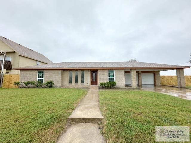 view of front facade with a garage, driveway, fence, and a front lawn