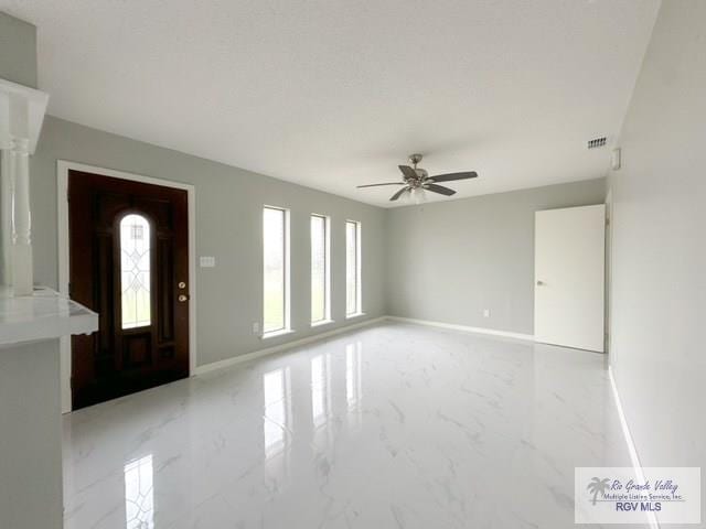 foyer entrance with ceiling fan, marble finish floor, visible vents, and baseboards