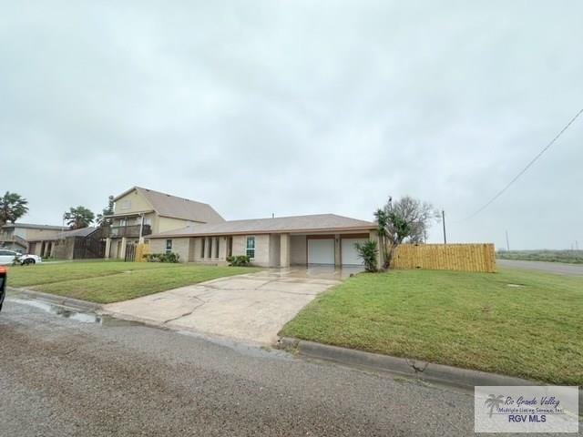 view of front facade with a garage, driveway, fence, and a front yard