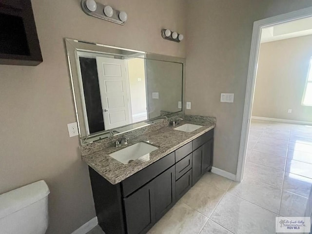 bathroom with tile patterned floors, vanity, and toilet