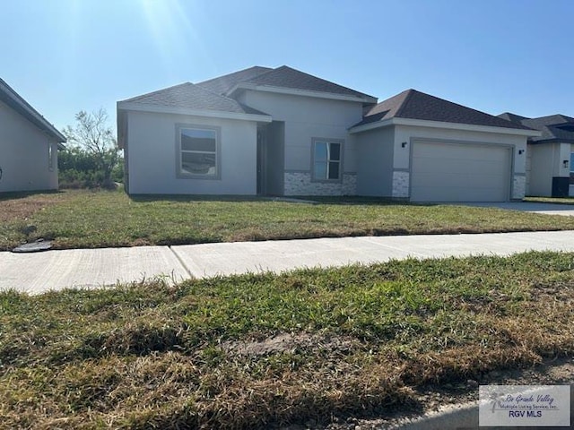 view of front of property with a garage and a front lawn