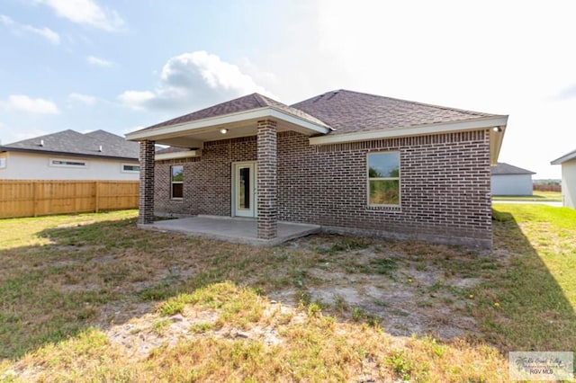 back of property featuring a lawn and a patio