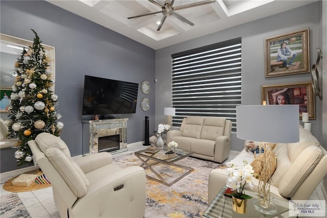 living room featuring coffered ceiling, a ceiling fan, beamed ceiling, and a premium fireplace