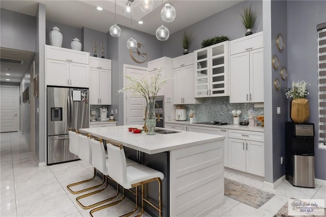 kitchen with stainless steel fridge with ice dispenser, light marble finish floors, a sink, black electric stovetop, and decorative backsplash